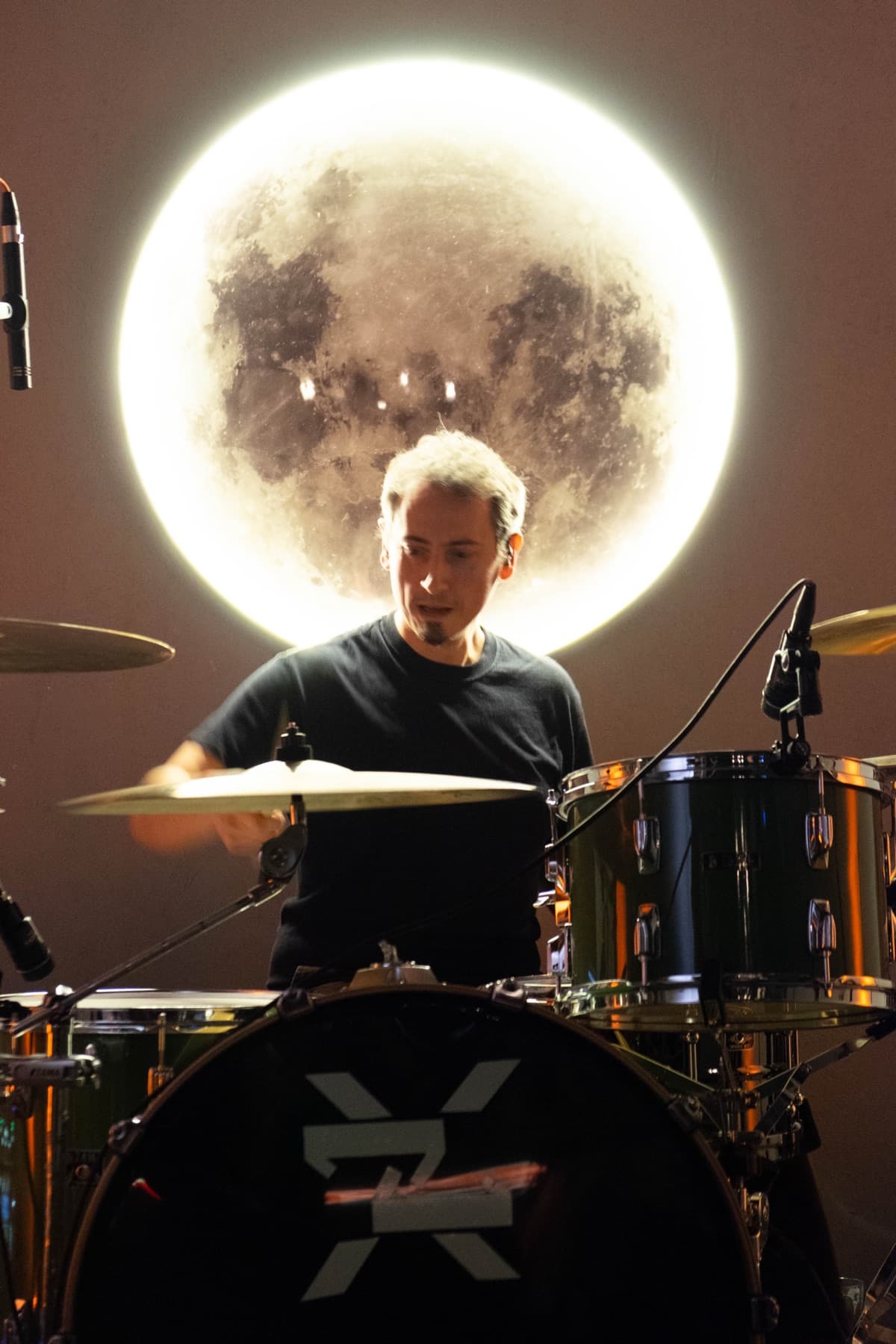 Bateristul, cu o lună mare luminată în spate